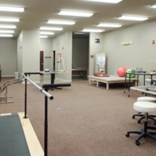 A physical therapy room equipped with exercise and rehabilitation equipment.