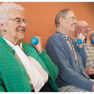 A group of seniors engaging in light weightlifting exercises as part of a healthy lifestyle routine.