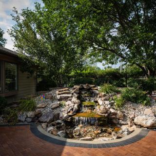 A serene garden with a cascading waterfall surrounded by lush greenery.