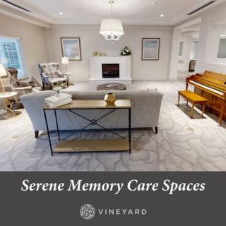 A serene and cozy memory care space with elegant interior design, featuring a sofa, piano, and fireplace.