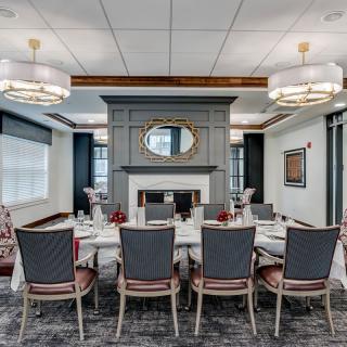 A luxurious dining room with an elegant table setting and a decorative fireplace.