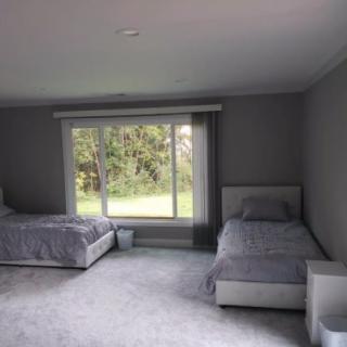 A minimalist bedroom with two beds and a large window.