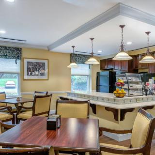 A cozy dining area with elegant furniture and soft lighting, featuring a small counter and seating for guests.