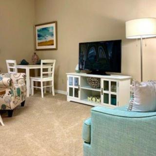 A cozy living room with a television, dining set, and soft lighting.