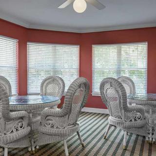A bright dining area with wicker furniture and red walls.