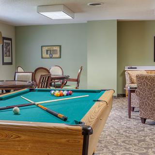 A cozy recreation room featuring a pool table and comfortable seating areas.