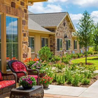 A picturesque suburban house with a beautifully landscaped garden and outdoor seating area.