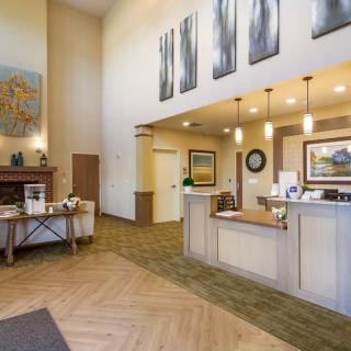A welcoming reception area with a front desk, artwork on the walls, and comfortable lighting.