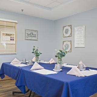 A well-arranged meeting room with a blue table setting, decorative flowers, and an inviting ambiance.