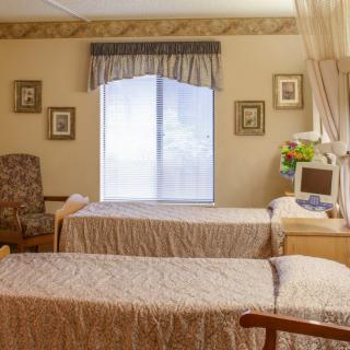 A hospital room with two beds, a window, and decorative elements.