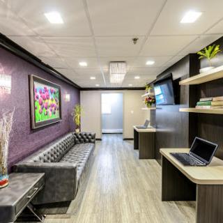 A modern and welcoming lobby featuring comfortable seating, vibrant artwork, and stylish decor.