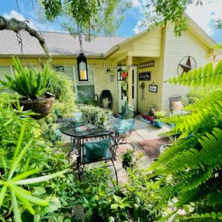 A serene garden setting featuring lush greenery and a cozy patio.
