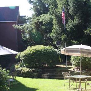 A sunny garden with patio furniture and a flag in the background.