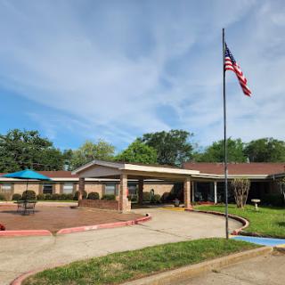 A well-maintained residential facility featuring an American flag and serene surroundings.