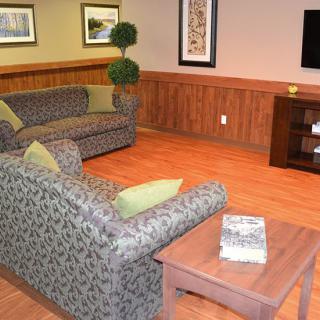 A cozy living room with patterned sofas, a television, and wooden flooring.