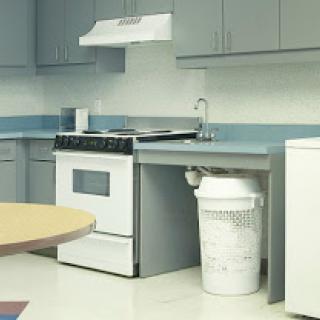 A modern kitchen featuring a stove, refrigerator, and sink with gray cabinetry.