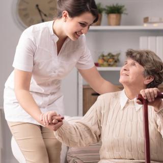 A nurse assists an elderly woman with care and support.