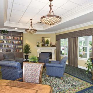 A cozy living room with armchairs, a fireplace, and built-in bookshelves.