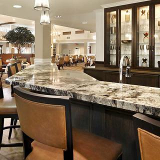 A modern bar area with a luxurious marble countertop and elegant seating.