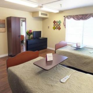 A shared bedroom with two beds, a television, and a wardrobe.