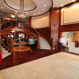 A luxurious hotel lobby featuring a grand staircase and elegant chandelier.