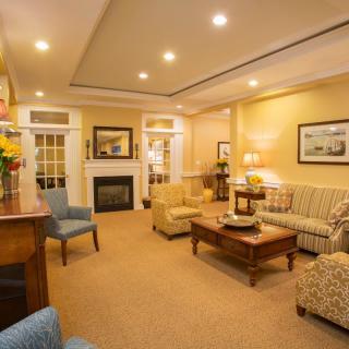 A cozy living room with various seating options and a fireplace.
