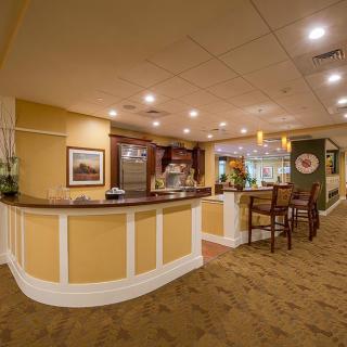 A warmly lit reception area with a front desk and seating.