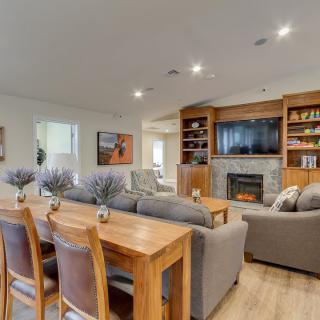 A modern living room with a cozy dining area, featuring a fireplace and built-in shelving.