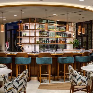 A modern bar interior with stylish seating and well-organized shelves.