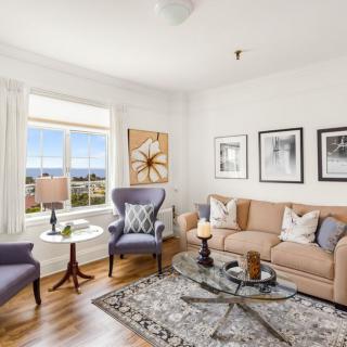 A cozy and elegantly decorated living room with comfortable seating and tasteful artwork.
