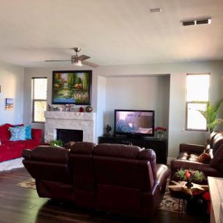 A cozy living room featuring a fireplace, leather sofas, and a television.