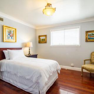 A cozy bedroom with a single bed and elegant decor.