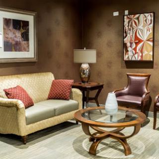 A cozy living room setup featuring a beige sofa, an armchair, a stylish coffee table, and decorative artwork.