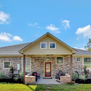 A charming brick house with a welcoming front porch under a clear blue sky.