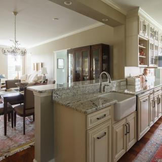 A cozy kitchen with a farmhouse sink opens into an elegant dining area.
