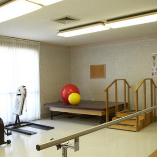 A well-equipped therapy room featuring exercise equipment and training aids for rehabilitation.