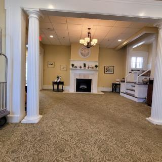 A spacious and inviting lobby area featuring elegant columns and a cozy fireplace.
