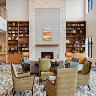 A cozy living space with a central fireplace, surrounded by bookshelves and comfortable armchairs.