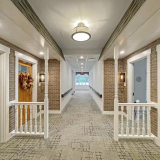 A well-lit hallway with decorated doors and carpeted flooring.