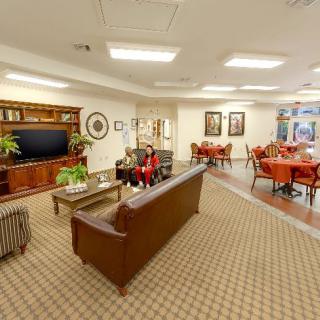 A well-furnished living room with a sofa, television, and seating area.
