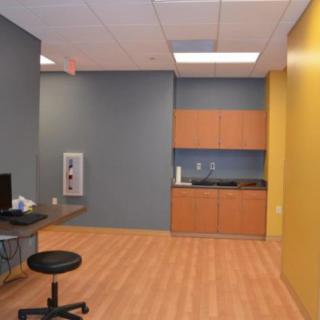 A modern office space with a desk, chair, and cabinets.
