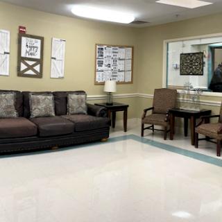 A cozy waiting area featuring a sofa, chairs, and decorative elements.