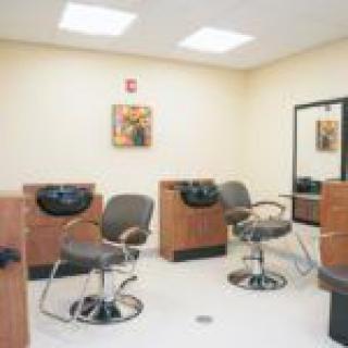 A brightly lit salon with chairs and hair washing stations.
