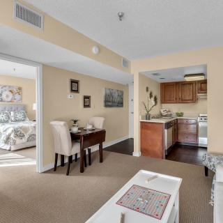 A cozy apartment interior featuring a living area, dining table, and a compact kitchen.