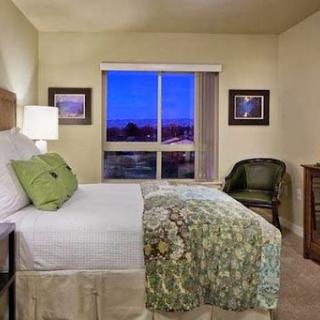 A cozy bedroom featuring a comfortable bed, elegant decor, and a scenic view through the window.