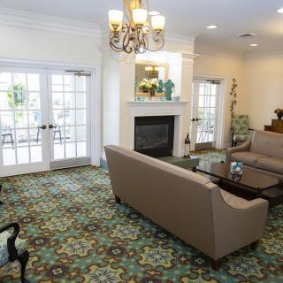 A comfortable living room with a sofa set, fireplace, and elegant chandelier.