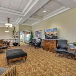 A spacious lobby area with comfortable seating, decorative plants, and framed artwork on the walls.