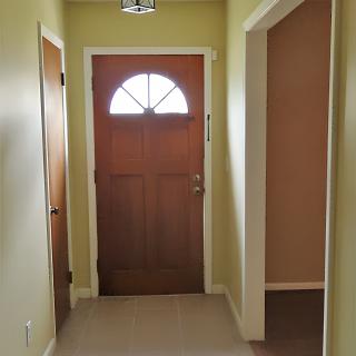 A hallway with an entrance door in a home.