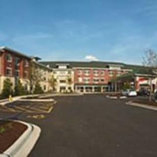 A hotel building with an adjacent parking lot.