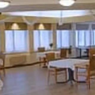 An empty dining area with tables and chairs arranged neatly near large windows.